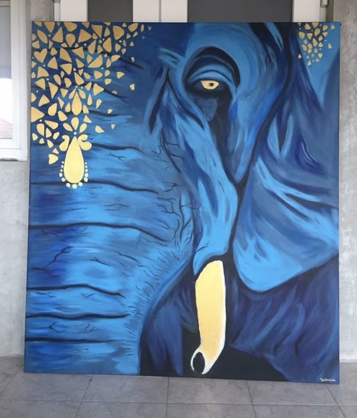 Painting of a blue elephant with gold-leaf accents